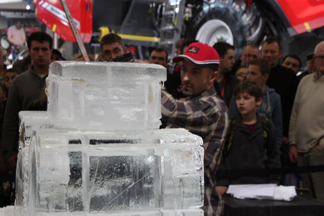 Un sculpteur peaufine son tracteur de glace devant de nombreux spectateurs. © Étienne Dupuis