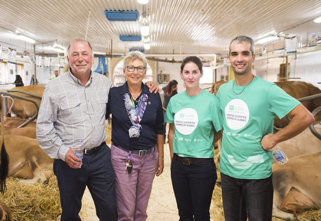 Le ministre Paradis lors de son passage dans une ferme laitière à Saint-Armand, en marge de la Journée portes ouvertes sur les fermes du Québec. Sur la photo, M. Paradis, sa femme Anne et les propriétaires de l’entreprise, Caroline Pelletier et Paulin Bard. Crédit photo : Martin Ménard