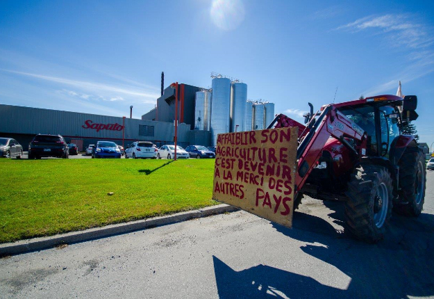 Certains agriculteurs ont conduit leur tracteur devant les usines de Saputo et d’Agropur avec des messages très clairs! Crédit photo : Martin Ménard/TCN