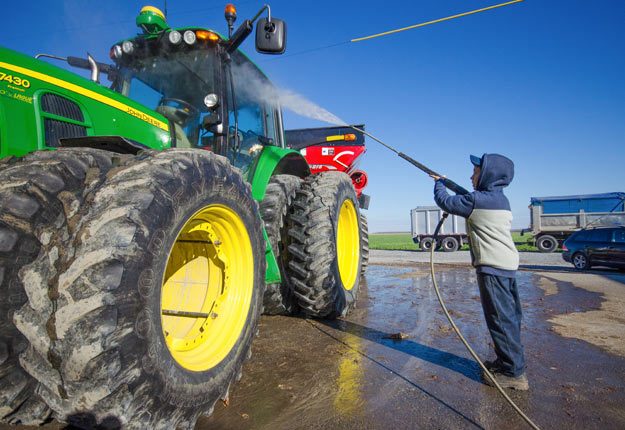 En travaillant pour un agriculteur, Mathias apprend des notions de base, c’est-à-dire des tâches amusantes, comme celle de conduire des tracteurs, et d’autres qui le sont un peu moins, telles que leur nettoyage. Crédit Photo : Martin Ménard/TCN