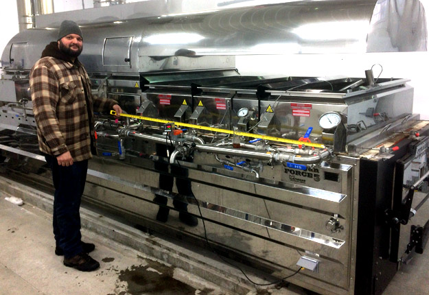 Vincent Poisson, conseiller au Club acéricole du sud du Québec, assure que certaines méthodes de fabrication du sirop créent davantage de saveurs. Il est d’ailleurs ici photographié alors qu’il mesure mesure la longueur occupée par les casseroles à fond plat sur un évaporateur, dans sa propre érablière à Stornoway, près de Lac-Mégantic. Crédit photo : Gracieuseté.