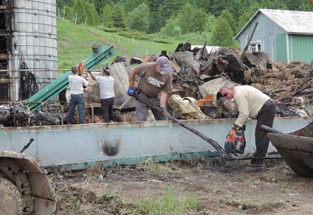 Une corvée organisée principalement sur Facebook a réuni une quarantaine de personnes à la Ferme du Gouffre. Celles-ci ont participé au nettoyage des débris qui jonchaient le sol à la suite de l’incendie qui a fait périr près de 180 bêtes. Photo : Louis Vignola/CIHO FM