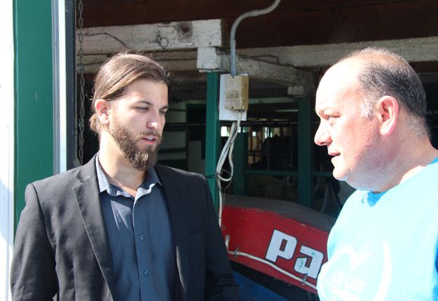 Simon Marcil, du Bloc québécois, donnait une conférence de presse dans une ferme laitière de la région de Mirabel en 2016. Il était ici en discussion avec l’ex-producteur de lait Réal Brière. Crédit photo : Archives/TCN