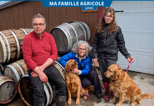 Vincent Noël, France Gagnon, leur fille Élia et les chiens Gadelle et Rayah devant le caveau de la ferme. Crédit photos : Johanne Lepage