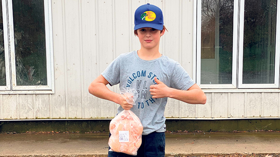 Scott Désilets, 12 ans, tient un de ses poulets qu’il a lui-même élevé et vendu au cours de l’été. Photo : Gracieuseté de Mélanie Vincent