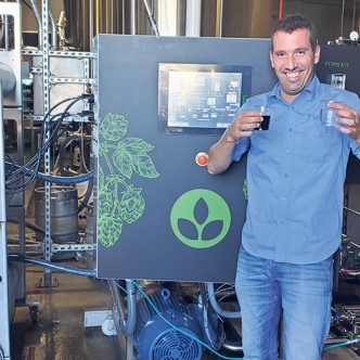 Matthieu Fortier, de H2O Innovation, montre les deux liquides obtenus par la nouvelle machine Hypermash servant à concentrer le moût de bière en sucre, dans les locaux de la brasserie Bottle Logic, en Californie. Photo : Gracieuseté de Matthieu Fortier