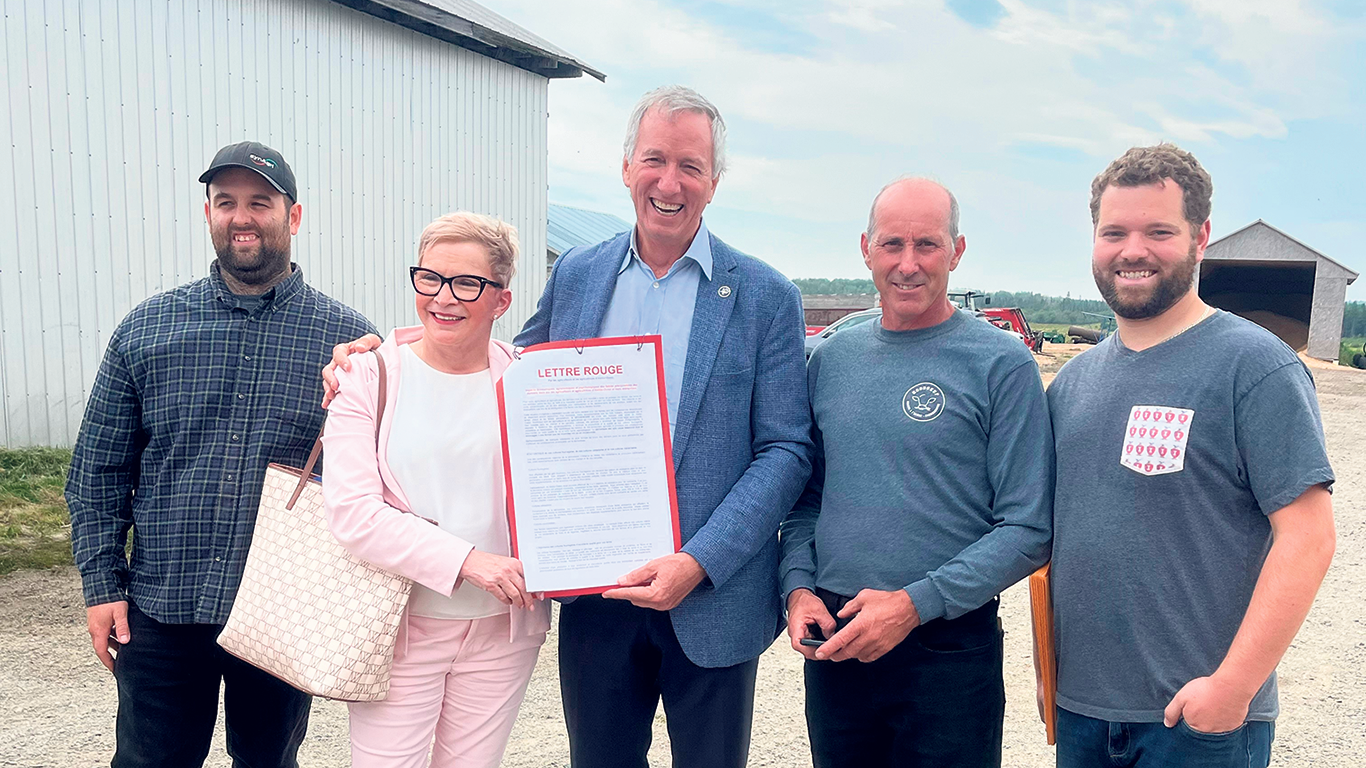 Les producteurs Mathieu Dumont, Éric Lafontaine et Maxime Fontaine ont pu remettre leur lettre rouge à la députée d’Abitibi-Ouest, Suzanne Blais, et au ministre de l’Agriculture, André Lamontagne. Photo : Audrey Drouin