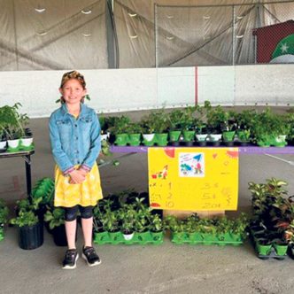 Zoé pratique ses mathématiques et développe ses habiletés sociales lorsqu’elle vend ses plants à La grande journée des petits entrepreneurs. Photo : Gracieuseté de Marie-Michèle Lambert