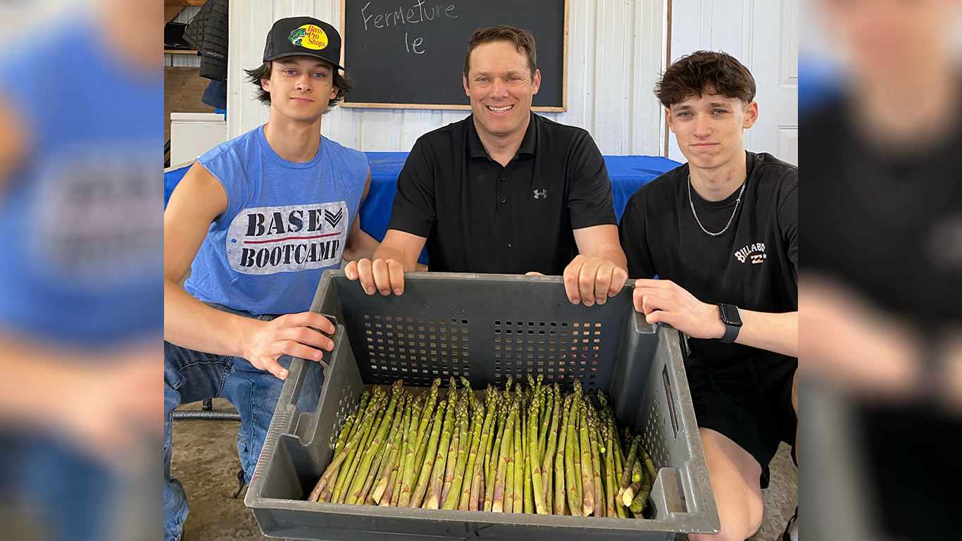 Julien Pagé, entouré de ses fils Justin et Antoine, passe plus de 15 heures par jour à récolter des asperges. Crédit : Gracieuseté de Julien Pagé