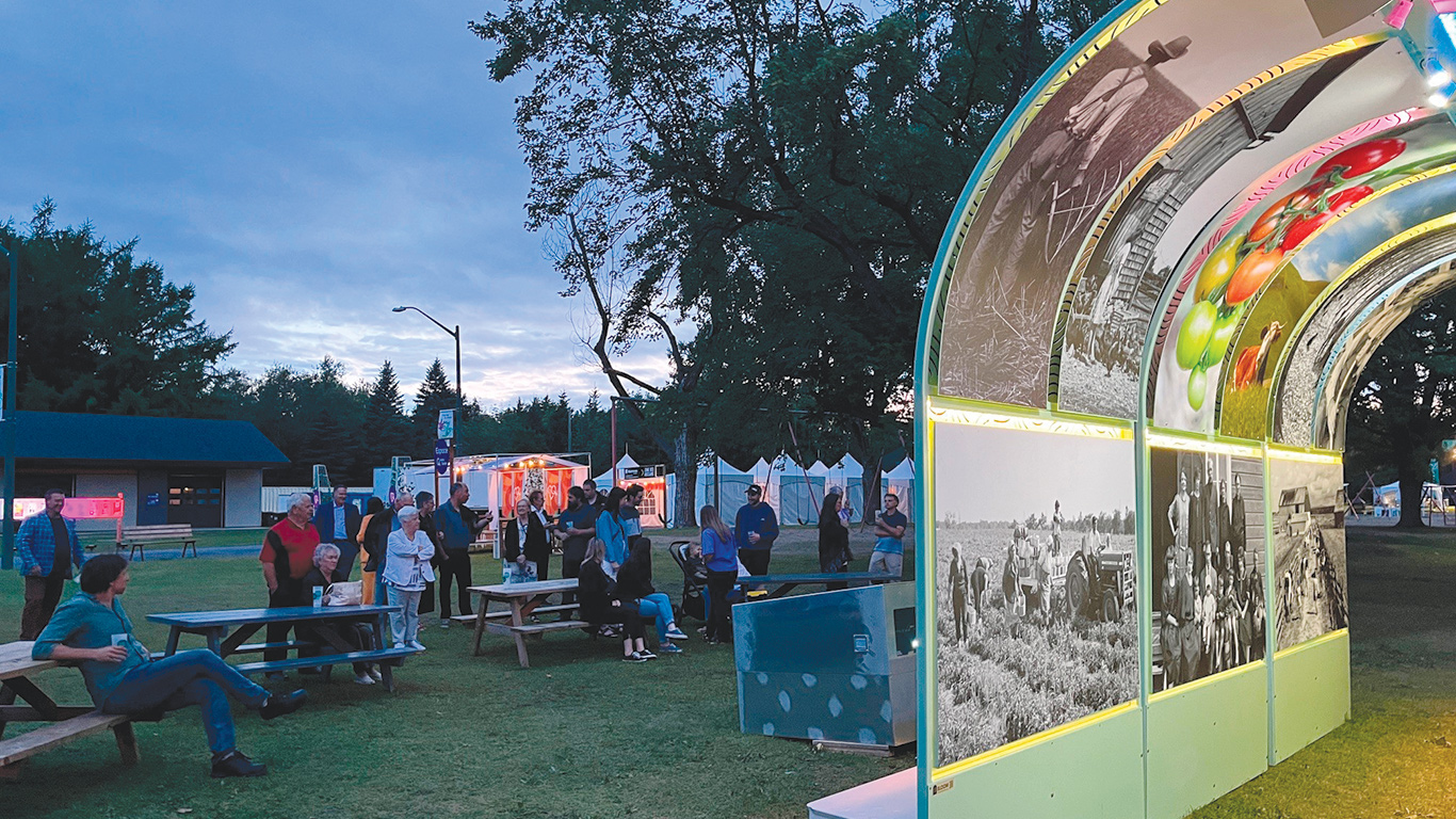 Durant toute la durée du Festival Mémoires et racines, les festivaliers ont pu regarder l’exposition de photos et visionner le film Habiter la terre, projeté sur la structure en arche du centième. Photo : Geneviève Quessy