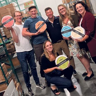 Simon-Pierre Bolduc (à gauche) et son équipe de la Fromagerie La Station, lors d’une visite au centre de distribution d’Éric Fréchette (au centre), au Vermont, l’été dernier. Photo : Gracieuseté d’Éric Fréchette