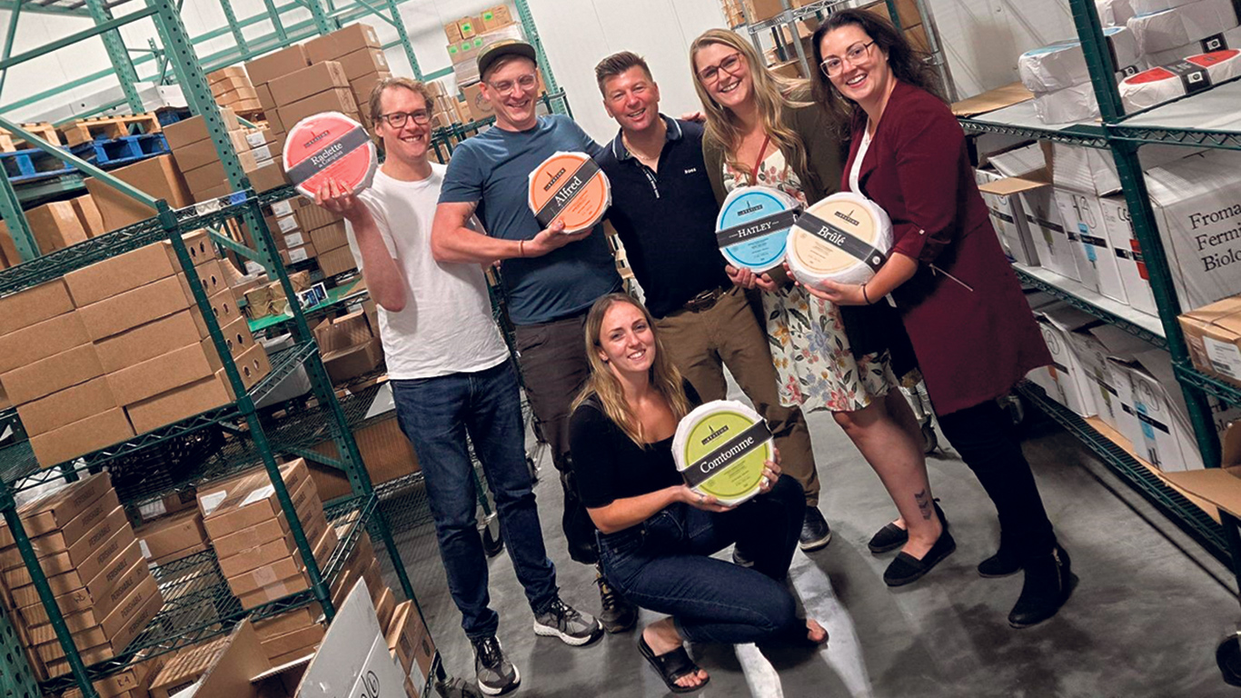 Simon-Pierre Bolduc (à gauche) et son équipe de la Fromagerie La Station, lors d’une visite au centre de distribution d’Éric Fréchette (au centre), au Vermont, l’été dernier. Photo : Gracieuseté d’Éric Fréchette