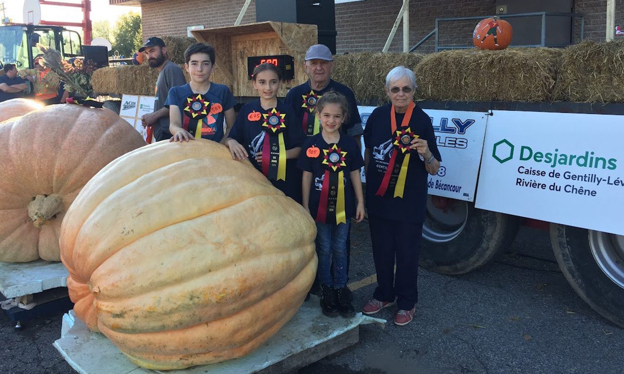 Lucie Roy, son conjoint Yvon Alain et leurs petits-enfants Miko, Xerha et Magaly ont le tour avec les citrouilles géantes. Ils ont fait bonne figure au 34e Potirothon de Gentilly. Photo : Gracieuseté de Lucie Roy