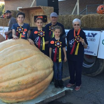 Lucie Roy, son conjoint Yvon Alain et leurs petits-enfants Miko, Xerha et Magaly ont le tour avec les citrouilles géantes. Ils ont fait bonne figure au 34e Potirothon de Gentilly. Photo : Gracieuseté de Lucie Roy