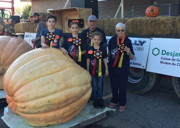 Lucie Roy, son conjoint Yvon Alain et leurs petits-enfants Miko, Xerha et Magaly ont le tour avec les citrouilles géantes. Ils ont fait bonne figure au 34e Potirothon de Gentilly. Photo : Gracieuseté de Lucie Roy