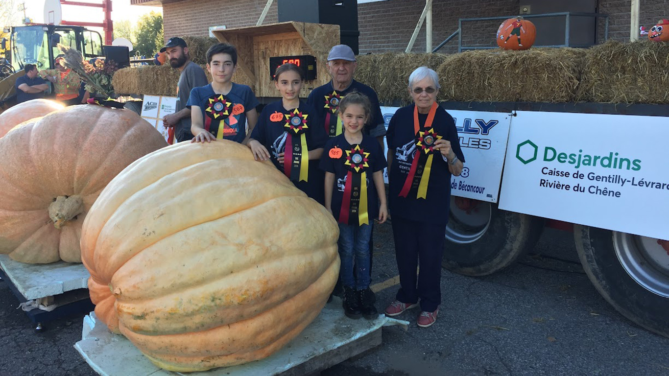 Lucie Roy, son conjoint Yvon Alain et leurs petits-enfants Miko, Xerha et Magaly ont le tour avec les citrouilles géantes. Ils ont fait bonne figure au 34e Potirothon de Gentilly. Photo : Gracieuseté de Lucie Roy