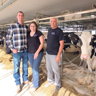 Antony Boutin, Marie-Christine Leclerc et Bernard Boutin, les copropriétaires de la Ferme Bergitte, expliquent que leur nouvelle étable offre une bonne luminosité naturelle et une ventilation favorisant le confort des animaux. Photo : Pénélope Leclerc