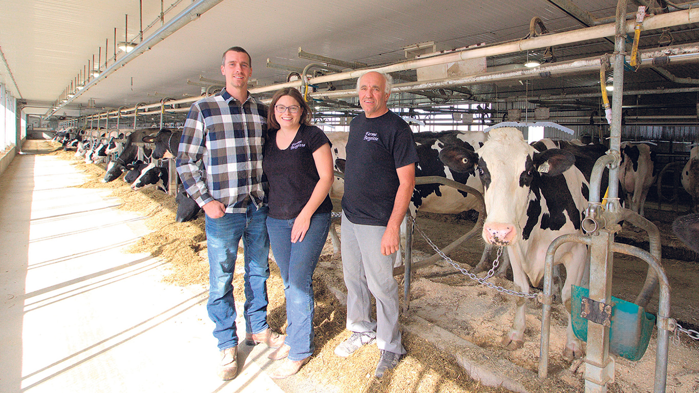 Antony Boutin, Marie-Christine Leclerc et Bernard Boutin, les copropriétaires de la Ferme Bergitte, expliquent que leur nouvelle étable offre une bonne luminosité naturelle et une ventilation favorisant le confort des animaux. Photo : Pénélope Leclerc