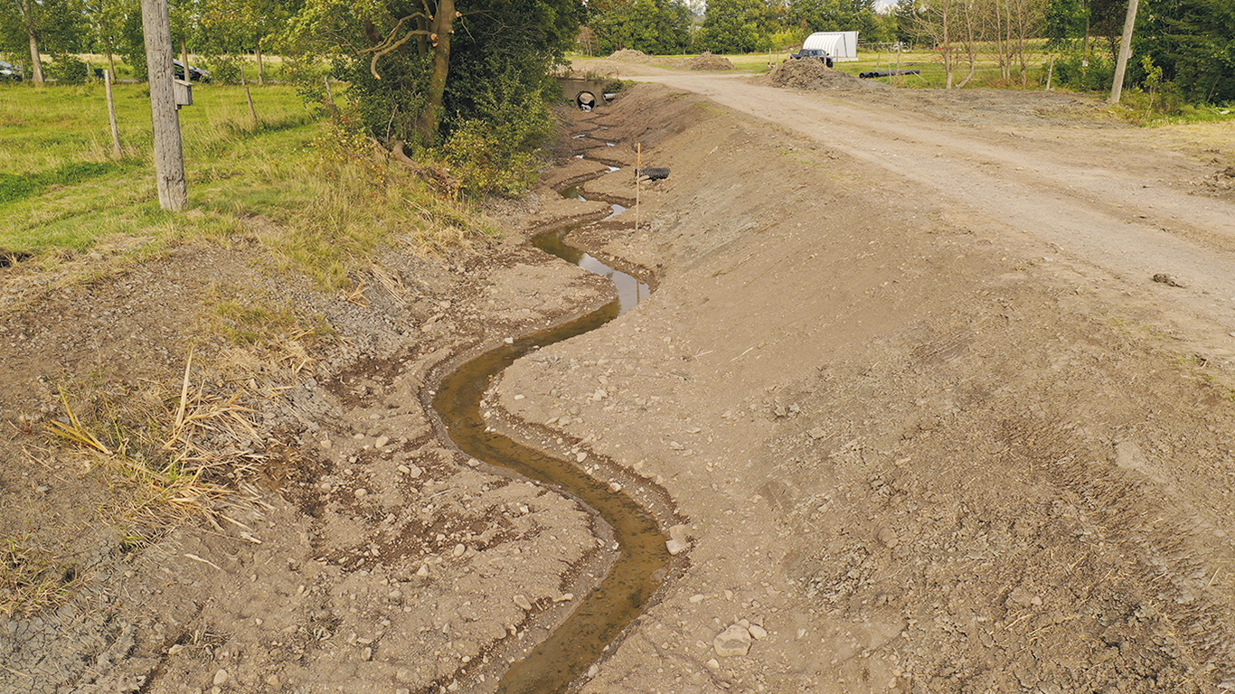 Un aménagement à deux étages a été réalisé dans le Bas-Saint-Laurent. Un petit chenal sinueux a été creusé dans le fond du cours d’eau. Il accroît la vitesse d’écoulement, diminue l’envasement et les besoins de nettoyage, tout en offrant des gains pour la faune et la flore. Photos : Gracieuseté de Rivières