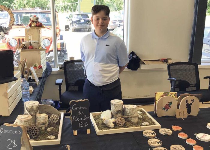 Damien Carbonneau, 10 ans, aime vendre ses différents produits confectionnés en bois dans des marchés. Photos : Gracieuseté de Mélissa Racine